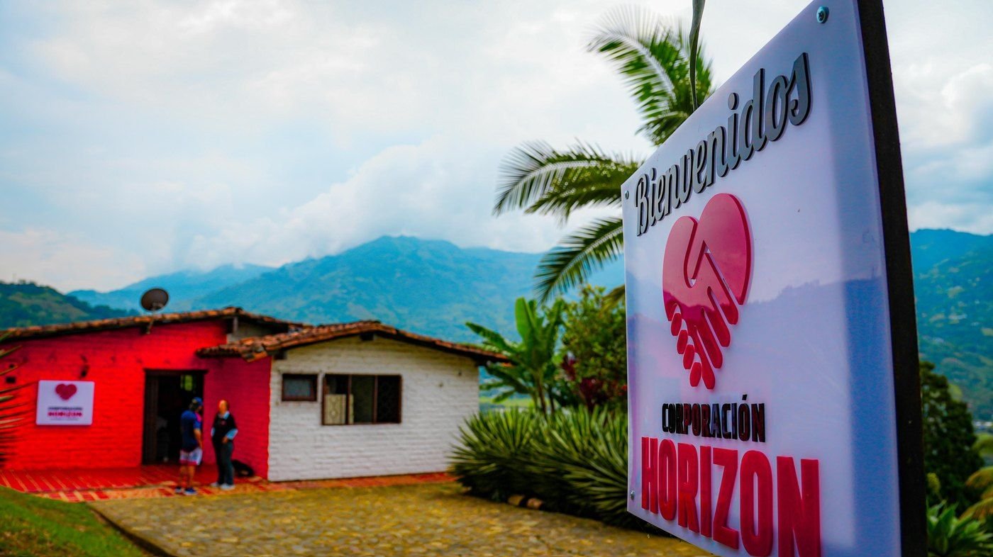 Letrero de bienvenida de Corporación Horizon frente a las montañas