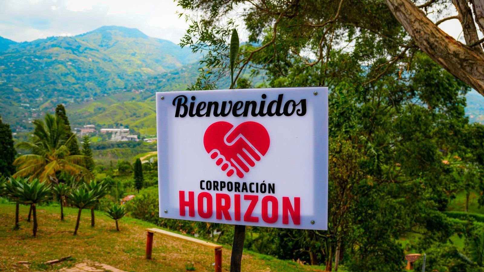 Letrero de bienvenida con las montañas de Girardota al fondo